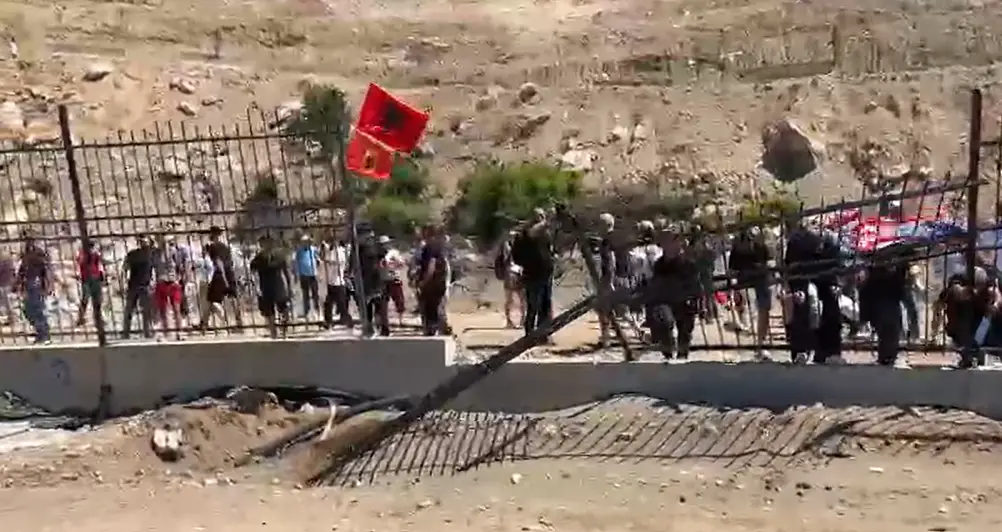Përplasje në Rrjoll, banorët rrëzojnë gardhin rrethues (VIDEO)